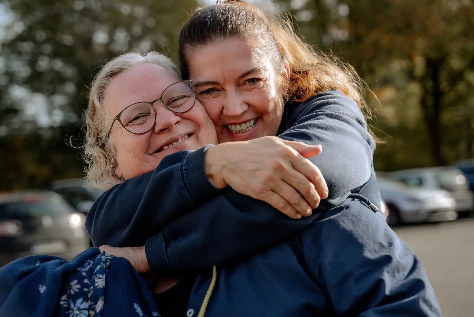 Zwei Mitarbeiterinnen des Heide-Pflegedienstes umarmen sich herzlich